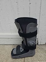 Left side profile of gray/black walking boot showing Velcro straps and sole