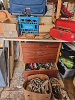 Overview showing Ryobi bag, red toolbox, drawers full of tools, cords in paper bag