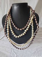 All four pearl necklaces draped on display bust