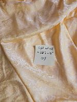 Bolt of light yellow silk brocade with size note