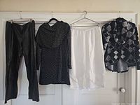 Four garments hanging: leather pants, polka-dot top, white capris, patterned jacket