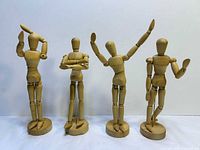 Front view of four wooden mannequins on stands