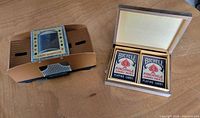 Automatic card shuffler next to open wooden box containing two Bicycle Pinochle decks