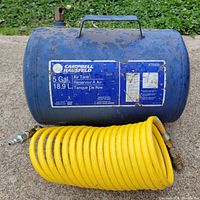 Full view of Campbell Hausfeld 5 gal blue air tank with attached yellow coiled hose