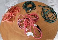 Top view showing four coiled extension cords, two red/pink and two green