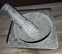granite mortar with pestle resting inside