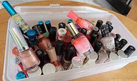 Top view of clear plastic bin filled with nail polish bottles