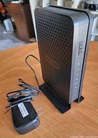 Front and side view of Netgear N600 modem router on stand with power adapter