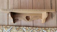 Front view showing shelf, brackets, floral motif, heart cutout