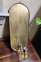 Front view of brass wall sconce on wooden surface