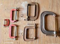 All six C-clamps laid out showing relative sizes and finishes