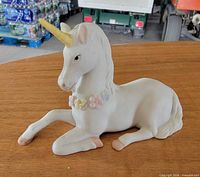 Full side view of reclining ceramic unicorn showing overall condition