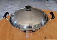 Wok with lid on, side handles visible