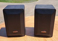 Front view of both Optimus speakers showing grilles and logos