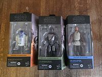 Front view of three Black Series boxes showing figures and accessories