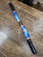 Full view of painted wooden didgeridoo on table