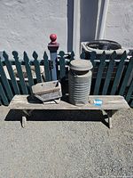 Full view of bench with metal can and planter