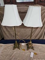 Front view of both brass-tone table lamps with shades