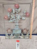 Full view of metal wall art with ruler for scale