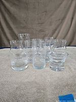 Front view of all ten clear glasses arranged on surface