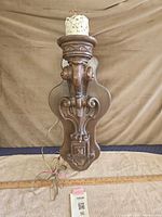 Full view of carved wooden wall sconce with faux candle