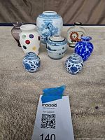 Group shot of eight miniature vases and jars on table