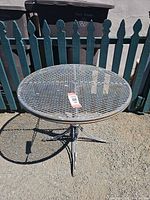 full view of round metal mesh table outdoors
