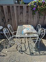 full view of white wrought iron table and four chairs outdoors