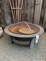 Full view of fire pit showing legs, bowl and mesh screen