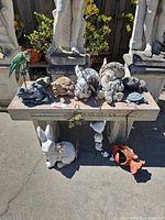 Full view of stone bench with animal figures and items beneath