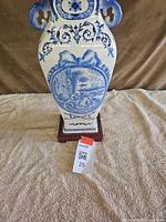 Front view of porcelain lamp body on wooden base showing blue chinoiserie scene