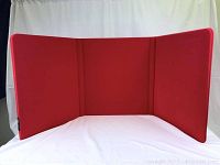 Red flannel three-panel folding display set up on white background.