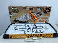 Full view of vintage Coleco Power Play table hockey game with original box and two goal nets, game surface with players and scoreboard