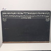 Front view of vintage chalkboard showing alphabet, numbers, and National School Slate Co. logo along top with black surface and wooden chalk rail at bottom.