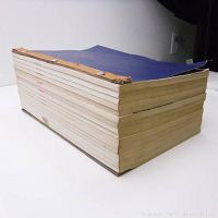 Side view of the thick blue hardcover dictionary showing the book's thickness and condition.