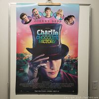 Front view of Charlie and the Chocolate Factory movie poster featuring Johnny Depp as Willy Wonka with child characters at top, vibrant colors and candy landscape background.
