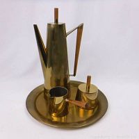 Full coffee set on white background showing tray with coffee pot, cream pitcher, and sugar container all featuring brass finish and wooden accents.