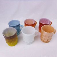 Photo showing all six mugs in a group with visible handles and diamond pattern texture.