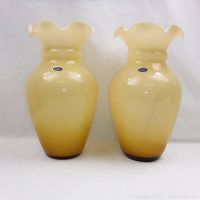 Front view showing pair of large pale yellow Murano glass vases with labels.
