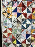 Close-up showing colorful patchwork triangle blocks and quilting pattern