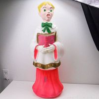Full view of the vintage choir boy blow mold outdoor light showing standing figure in white robe with red skirt and green bow tie holding hymnal.