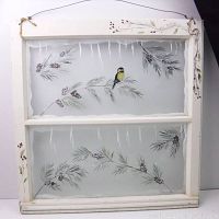 Full view of vintage window with painted winter scene including chickadee, pine boughs, and pine cones on glass panes and painted wood frame with inscription.