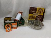Vintage Kitchen Items including Magic Cake Pan set of 3 with original box, aluminum Cooky and Pastry press, and additional small kitchen accessories in box
