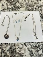 Overview of all three necklaces and matching earrings on white background