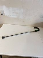 Full view of aluminium cane showing curved handle and rubber tip