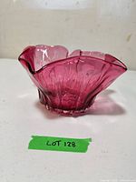 Oblique view showing cranberry glass bowl profile and ruffled rim