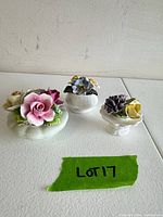 Three bone china floral figurines on tabletop