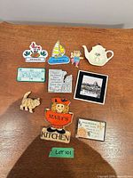 All 10 fridge magnets laid out on wood surface
