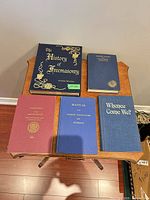 Five Freemasonry books arranged on small table, showing titles and cover types