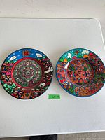 Both hand-painted plates side by side on table